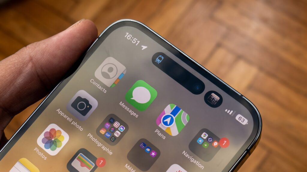 Gros plan sur l'écran d'un iPhone 15 reconditionné avec quelques applications visibles.